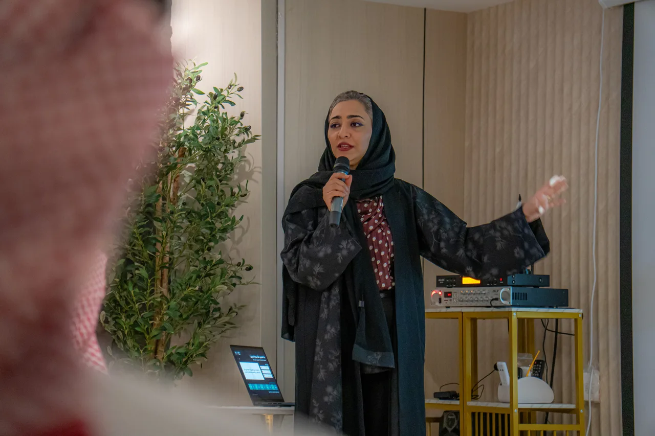 مقدّمة اللقاء واقفة تتحدث بالميكروفون