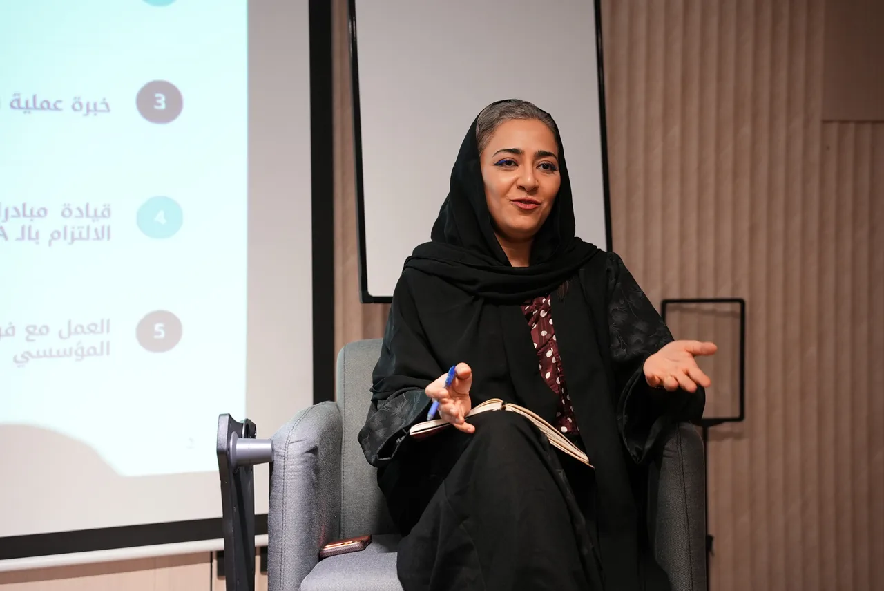 المتحدثة جالسة تشرح بيديها أثناء الحوار